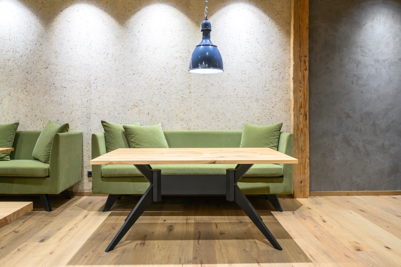 Gemütliche Lounge-Ecke mit grünen Samtsofas und Holztisch in einem Hotel